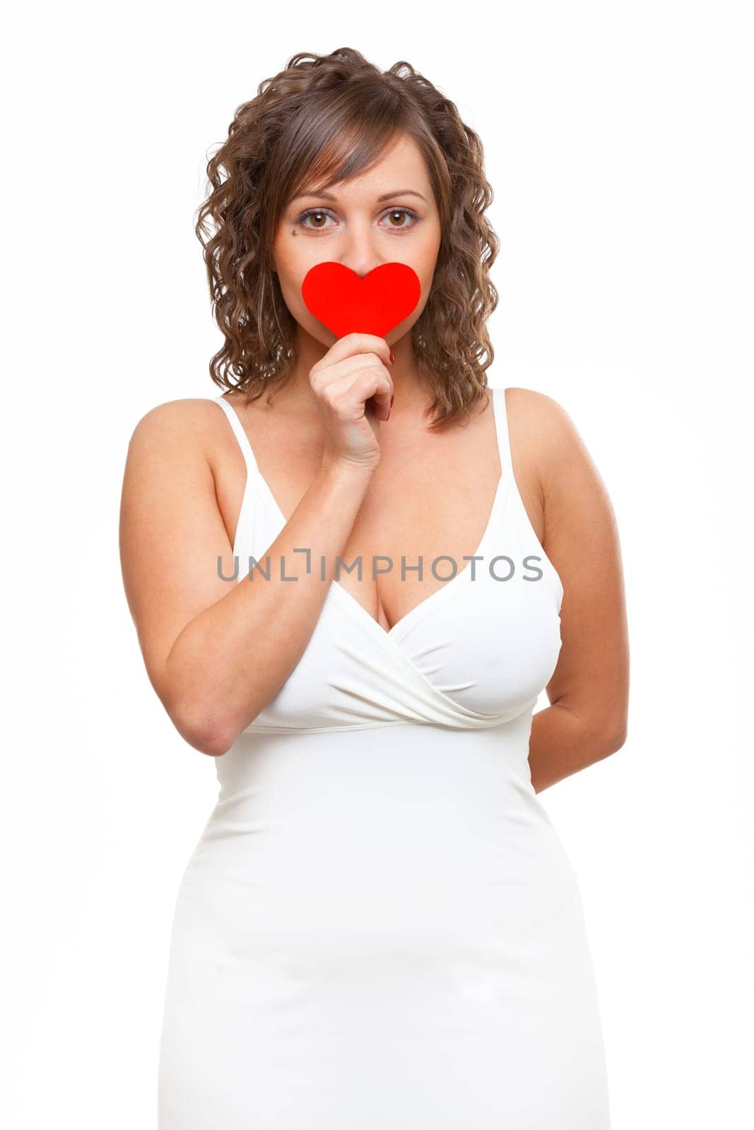 Young attractive woman holding red paper heart like a valentine card and hiding her face