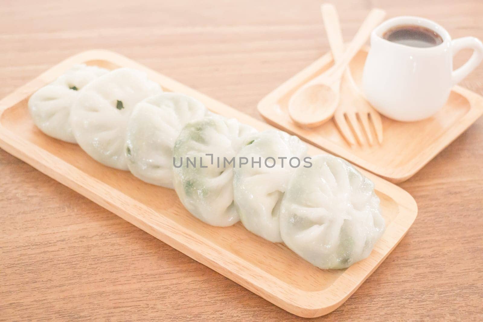 Steamed dumpling stuff serving on wooden plate, stock photo