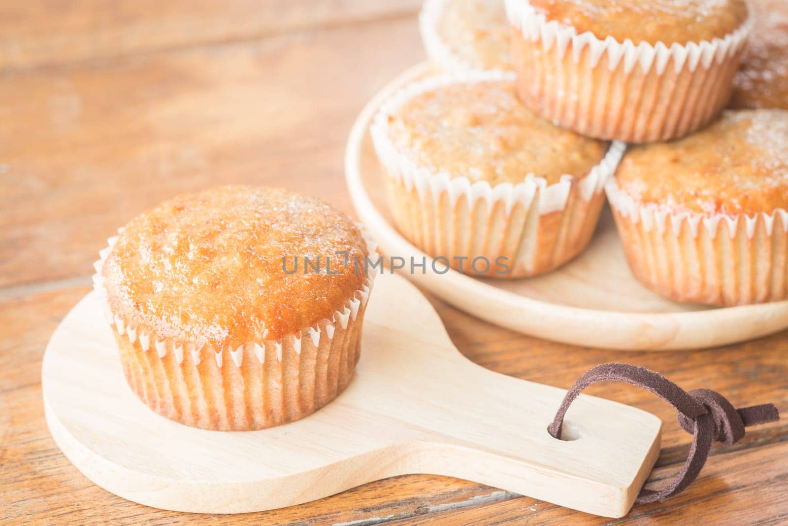 Homemade banana muffins on wooden plate, stock photo