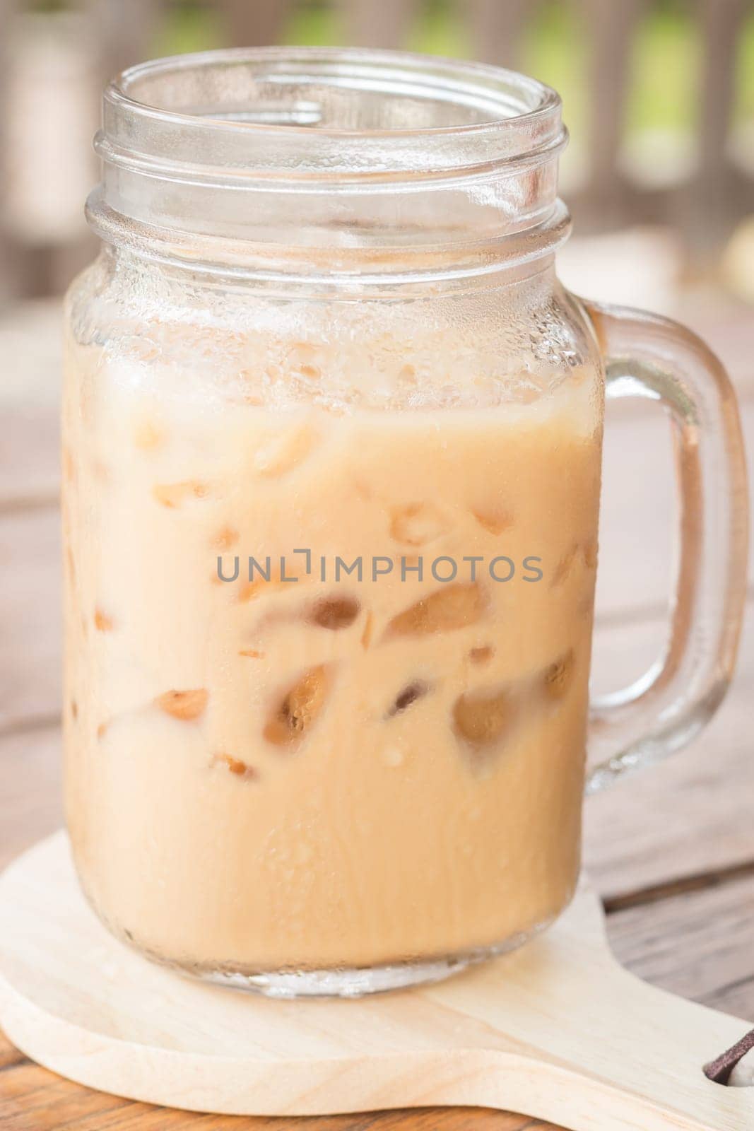 Iced milk coffee on wooden table, stock photo