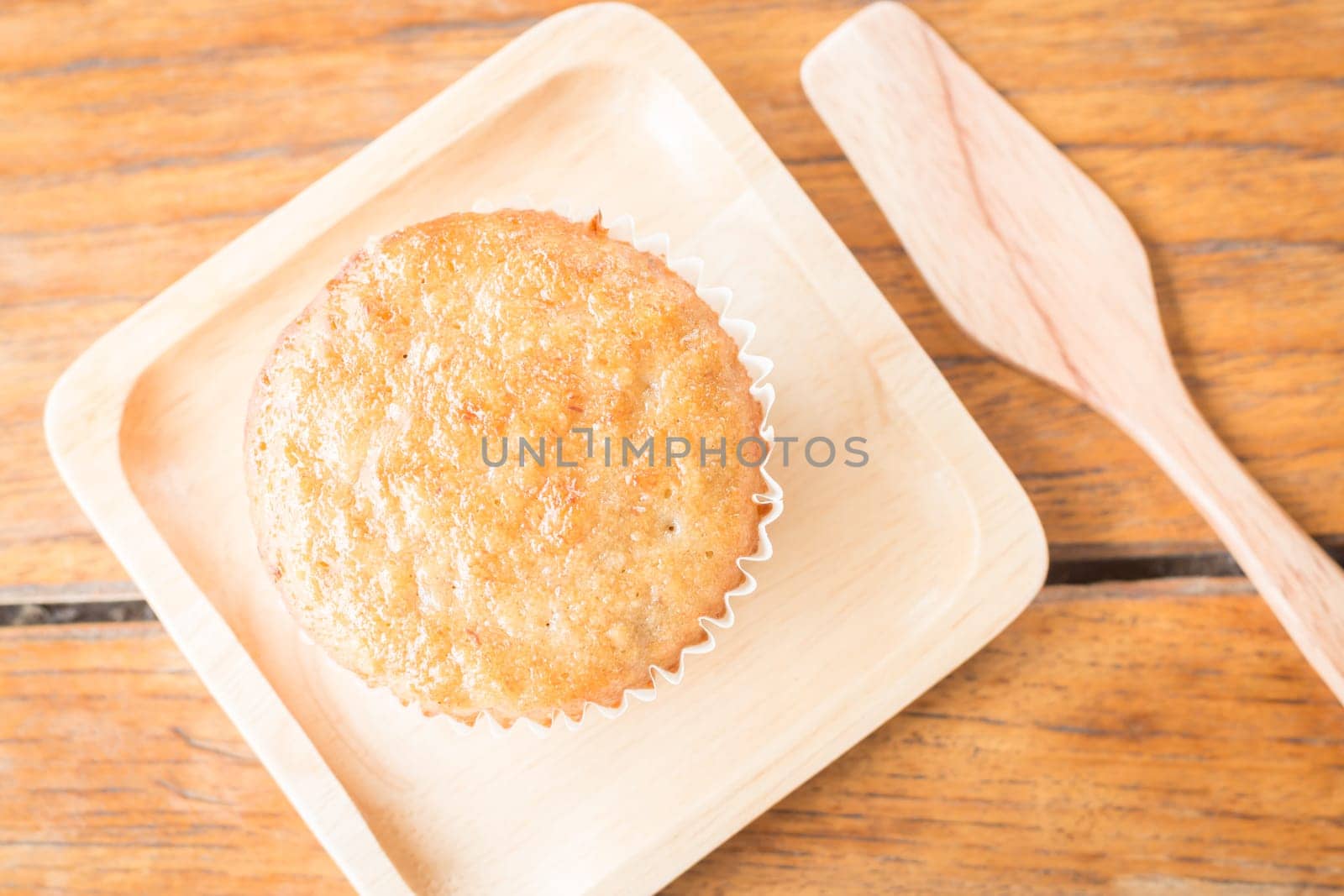 Homemade banana cupcake on wooden plate, stock photo