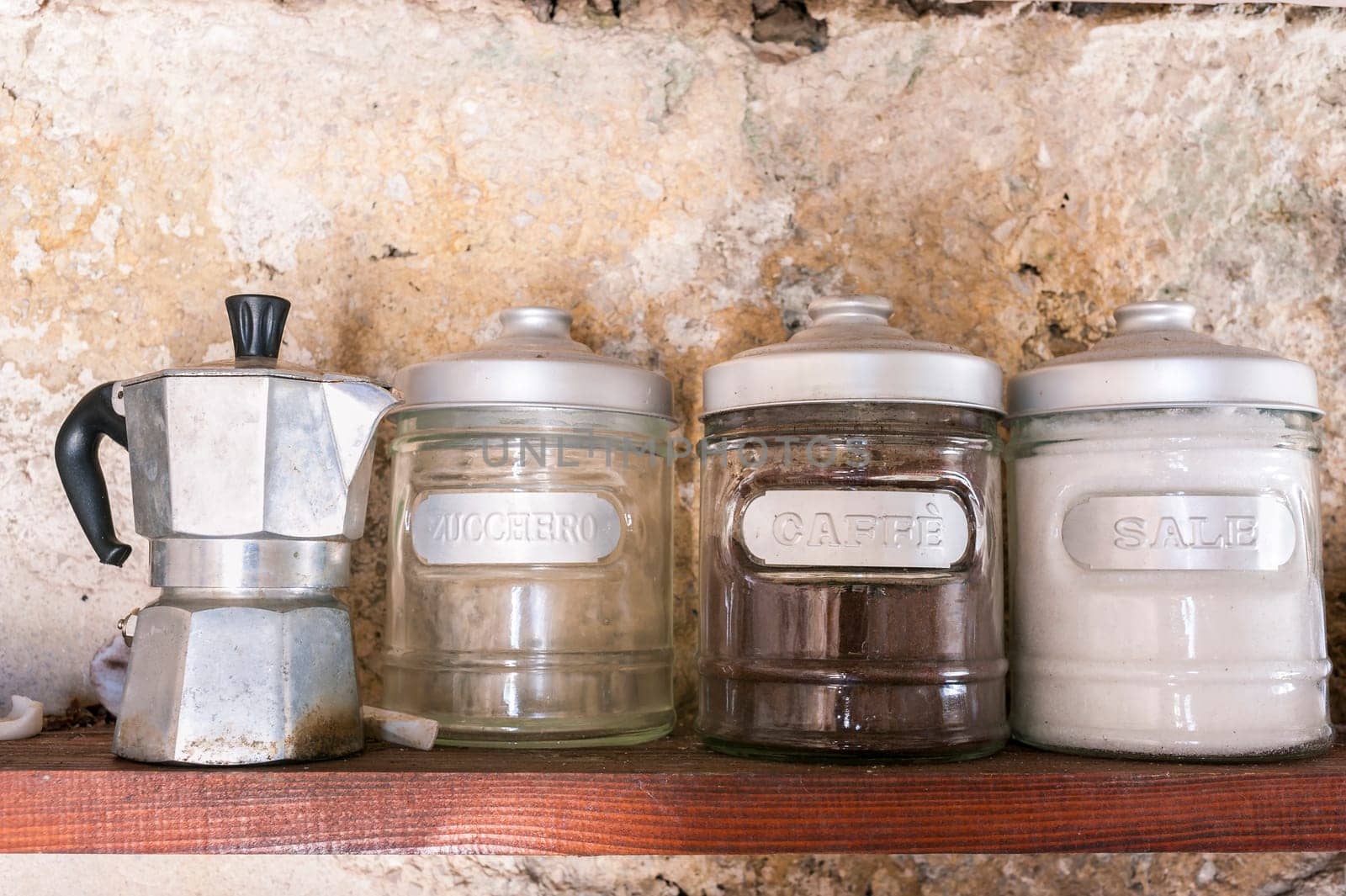 Old coffee pot on a shelf with cans of coffee, sugar and salt.