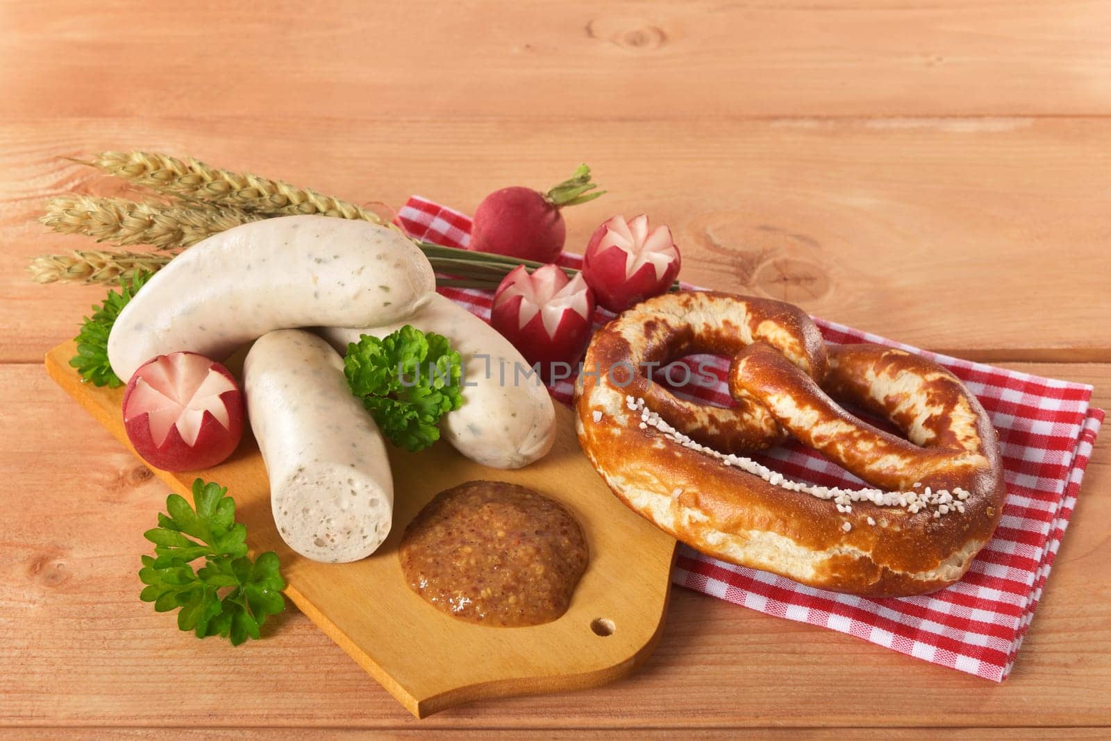 White sausage breakfast with sausages,pretzels and sweet mustard on wooden board