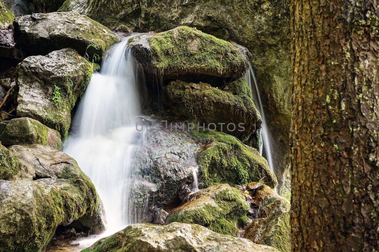 Waterfall mountain river,blurred water between stones with moss