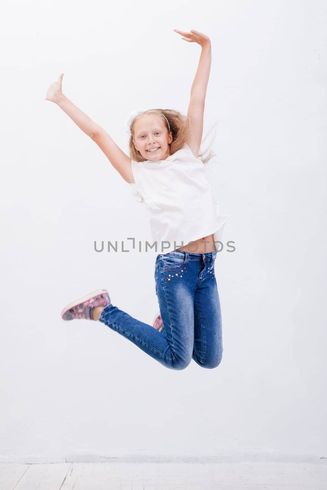 happy young girl jumping over a white background