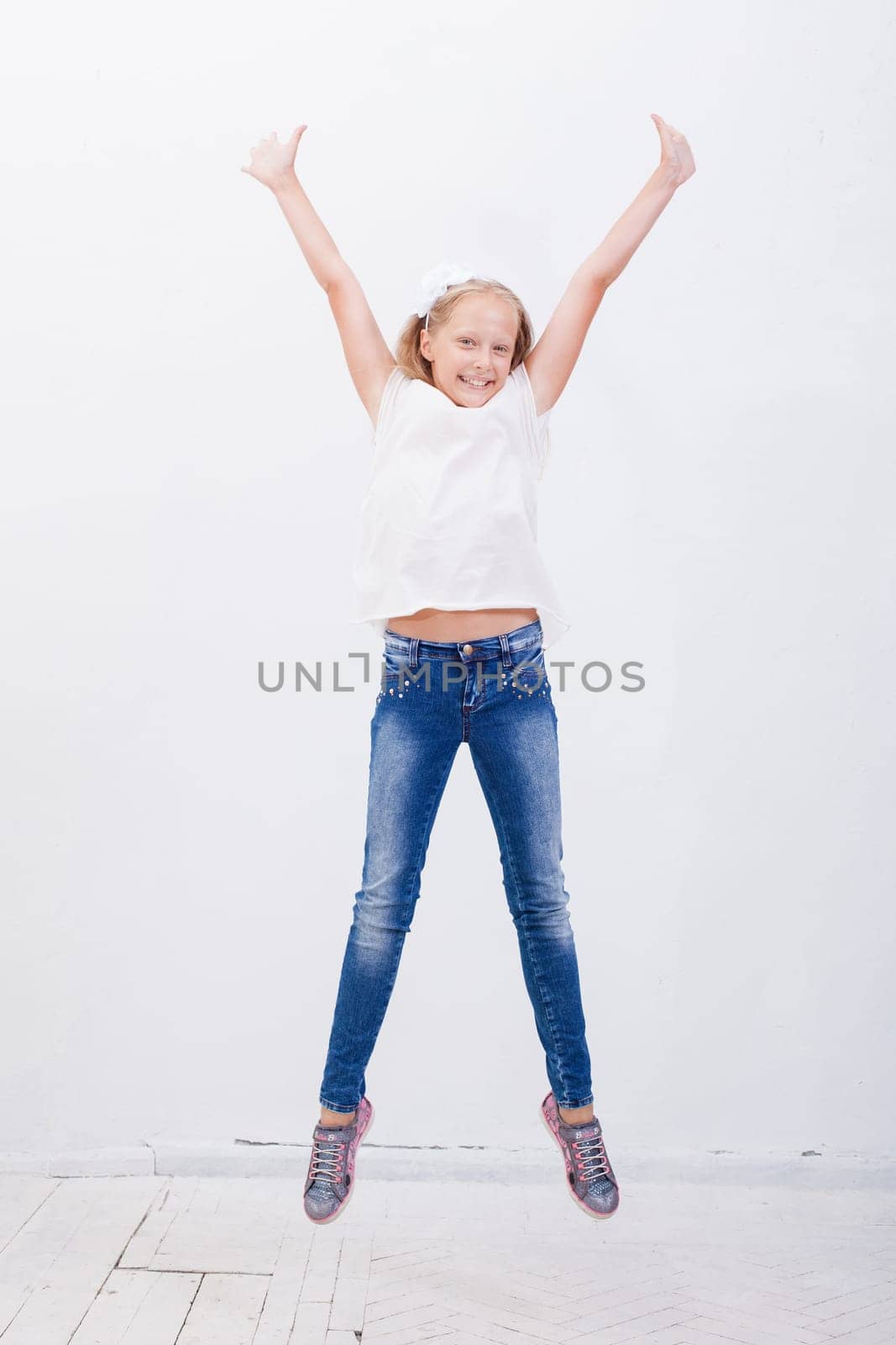 happy young girl jumping over a white background