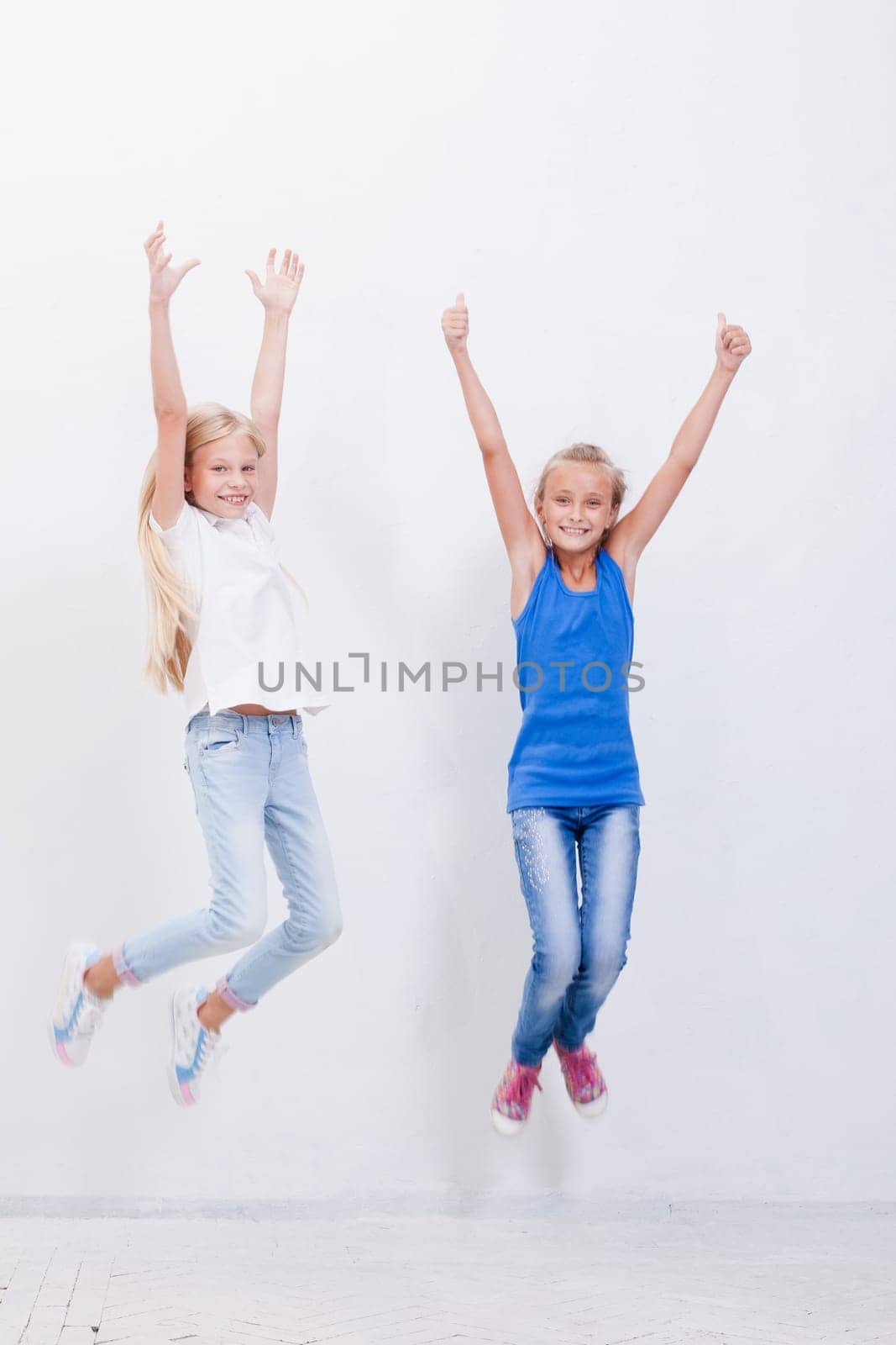 Group of happy young teens jumping over a white background
