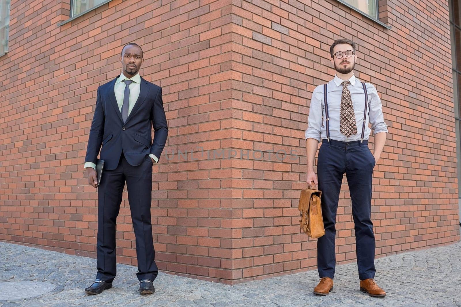 Portrait of multi ethnic business team. Two men standing against the backdrop of the city. The one man is African-American, other is European. concept of business success