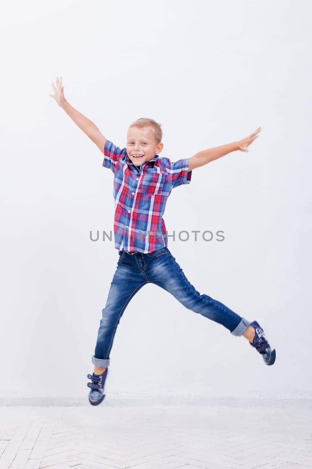 happy young boy jumping over a white background