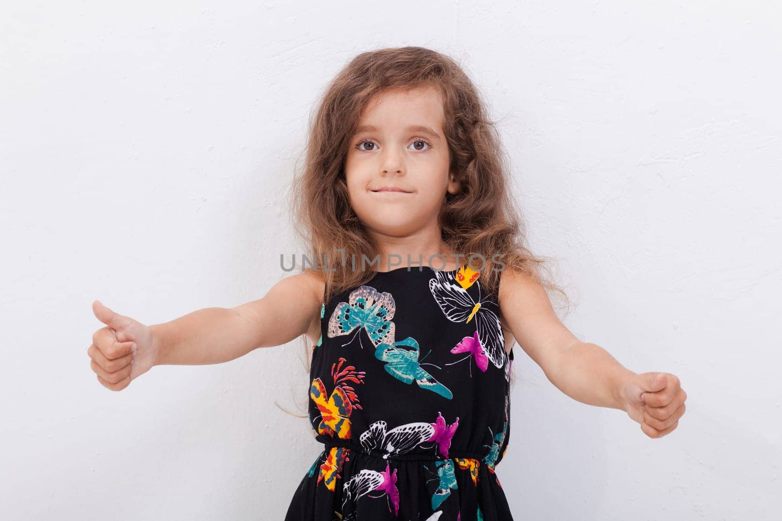 Portrait of a beautiful smiling girl showing thumbs up on white background