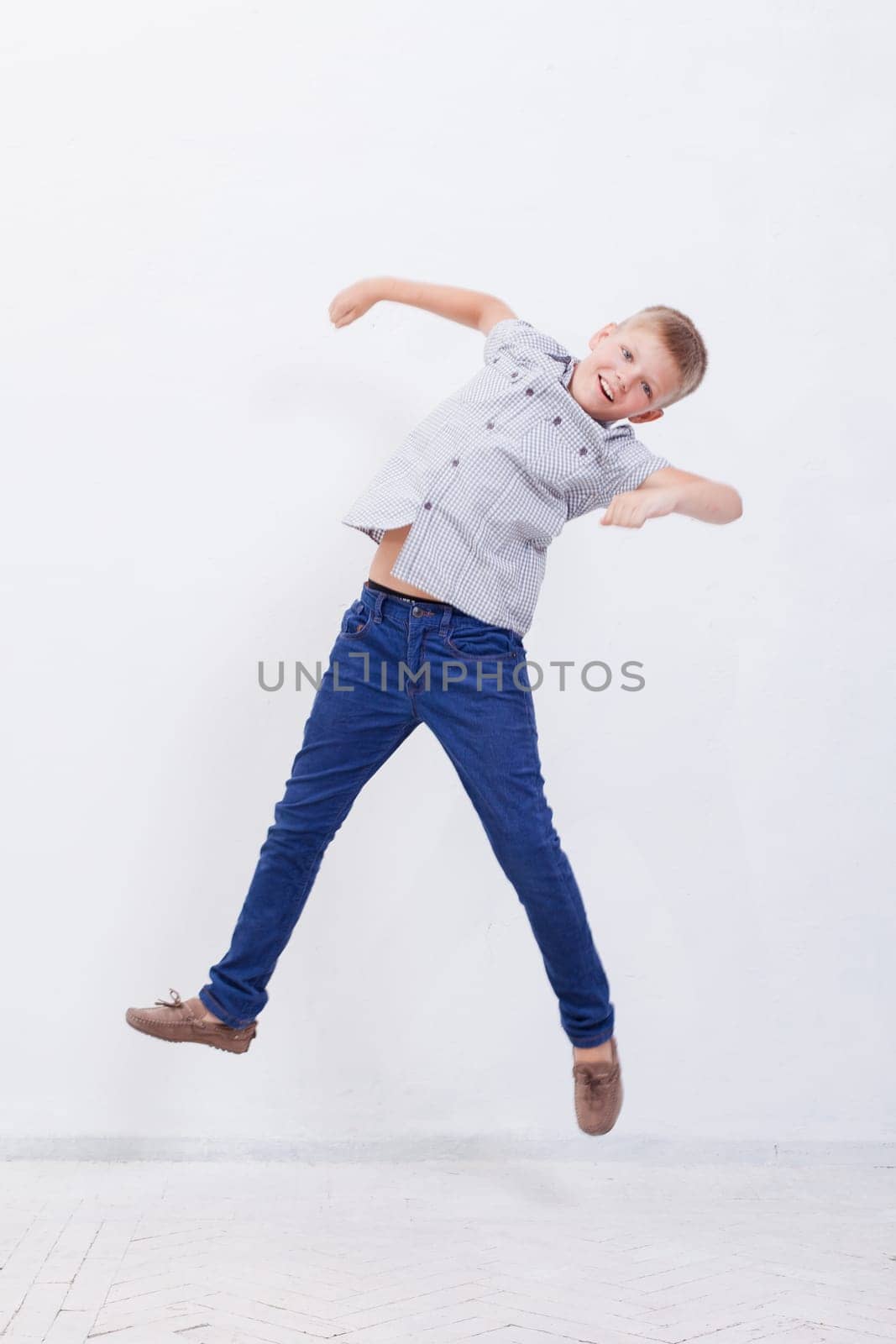 happy young boy jumping over a white background