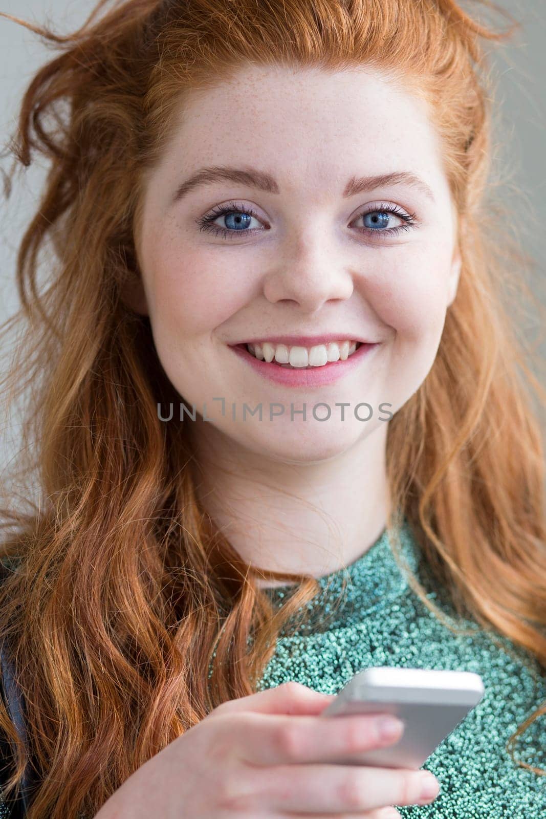 Attractive teenage girl with a smart phone in her hand.