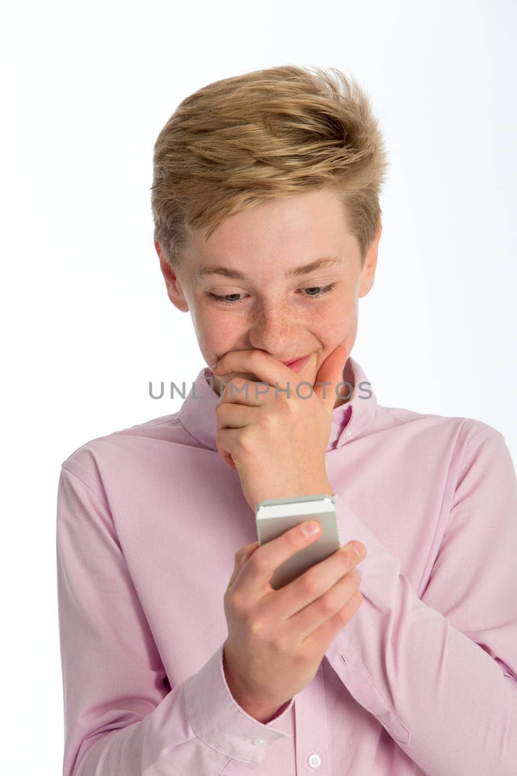 Teenage boy looking shocked at something on his smartphone. Close up shot against a white background.