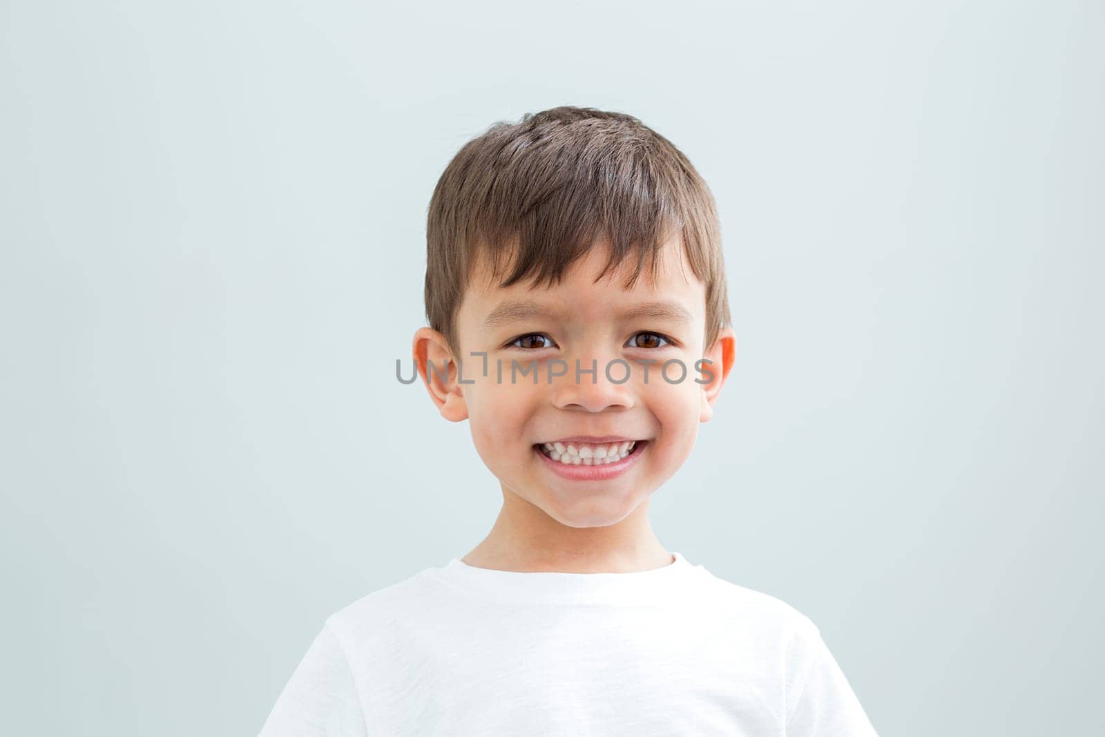 Landscape headshot of a young boy against a plain background