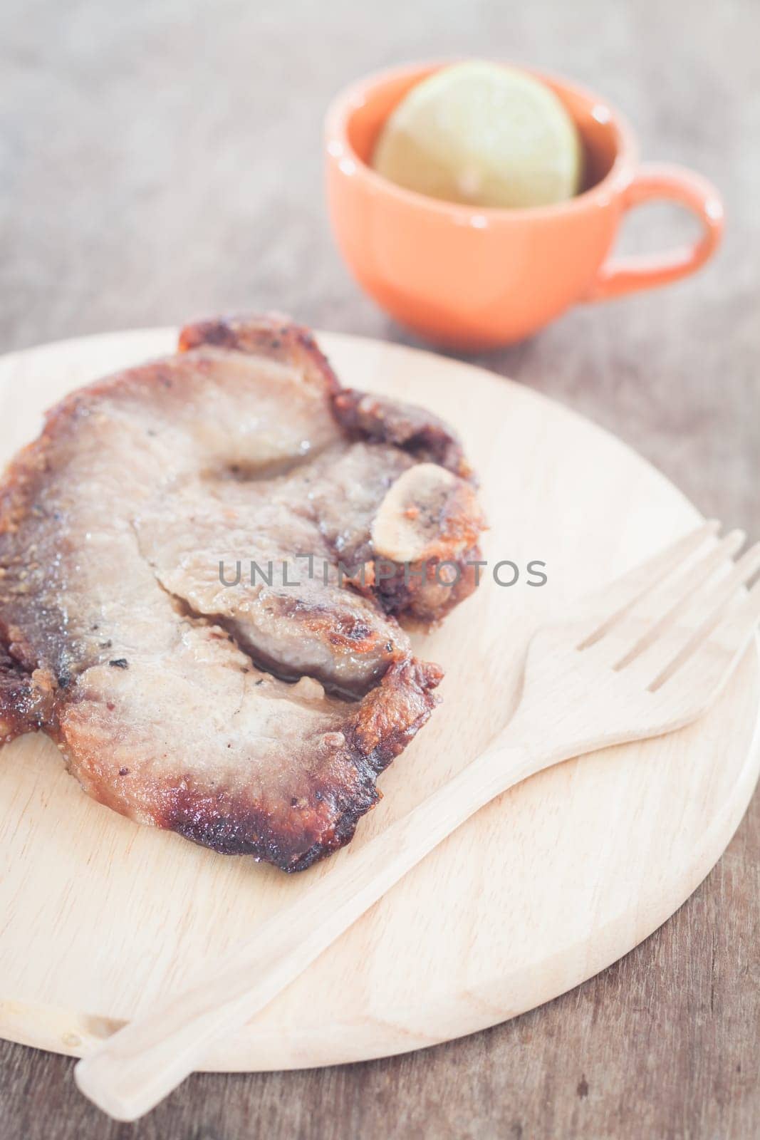 Pork steak on wooden plate, stock photo