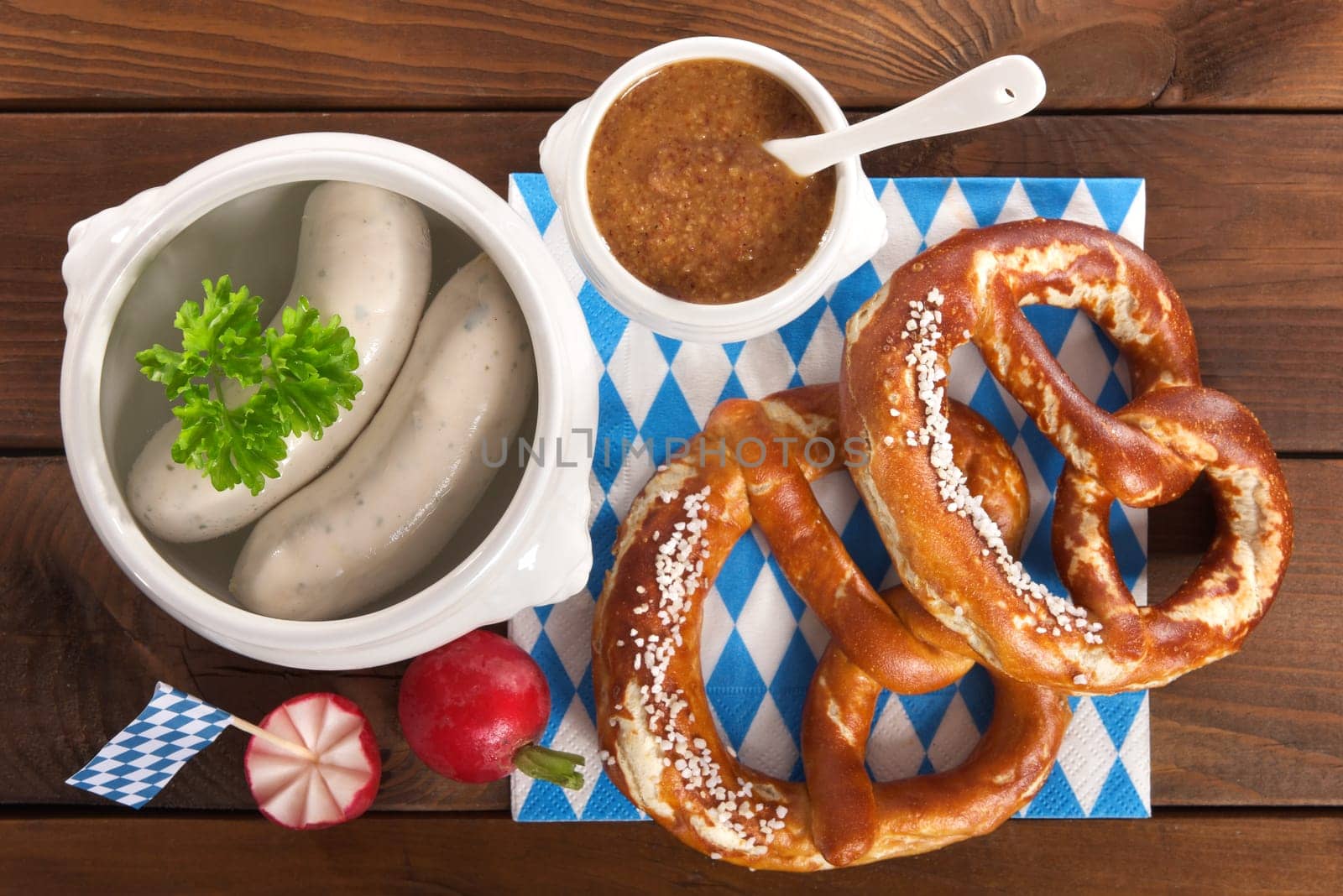 White sausage breakfast with sausages,pretzels and sweet mustard on wood substrate