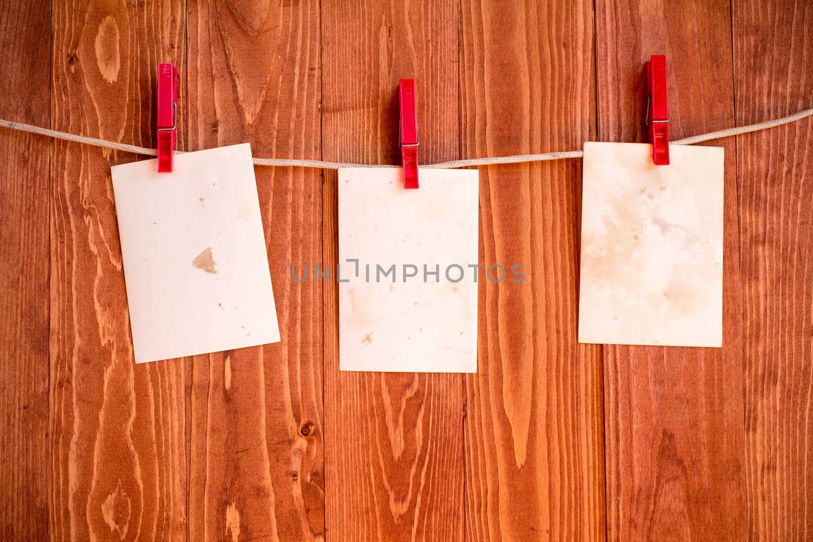 Photo  frames hanging on a rope over wooden background