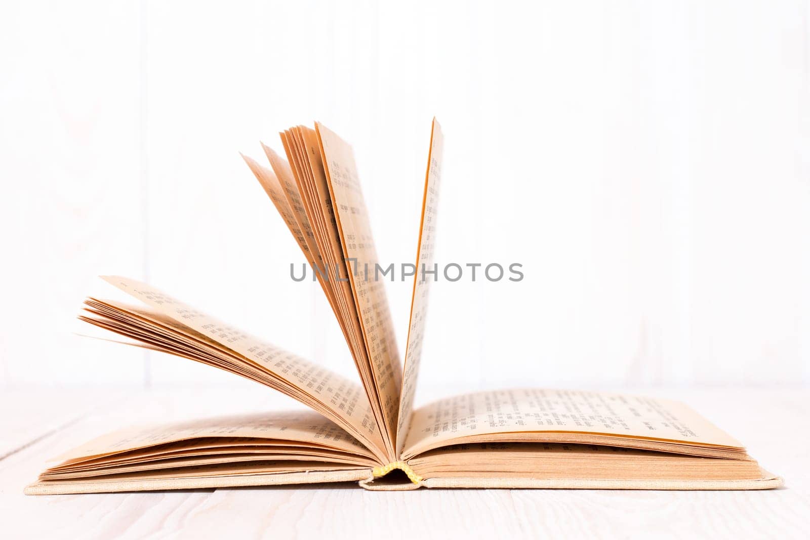 Open book on  white wood background. With place for text