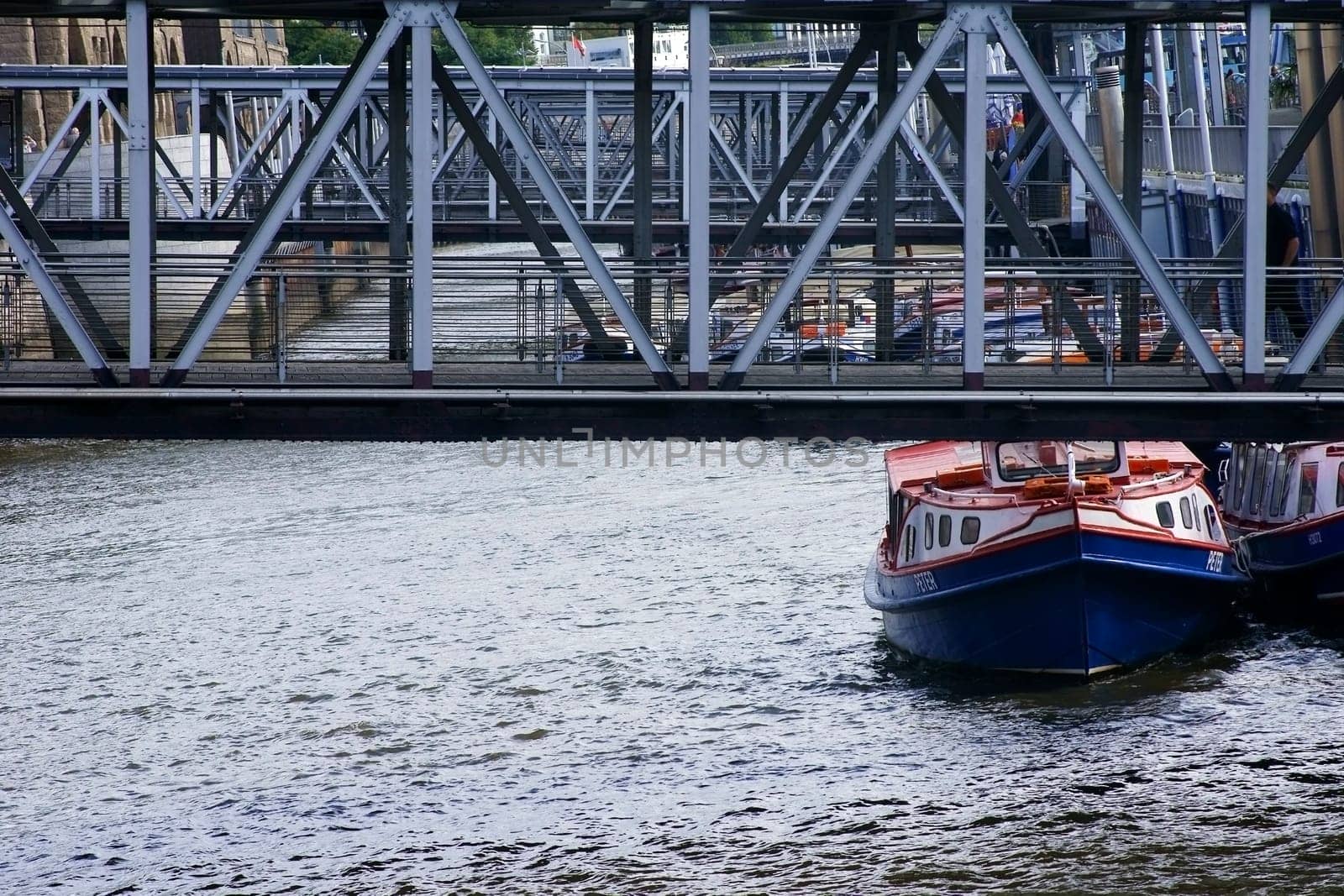 Hamburg,Germany – September 21,2014: Steel railings and bridges at the landing bridges in the port of Hamburg with a canal and excursion boats on September 21,2014 in Hamburg.