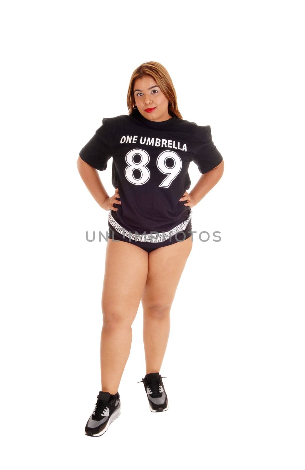 A shabby young East Indian woman in a black top and short pants standing.isolated for white background..