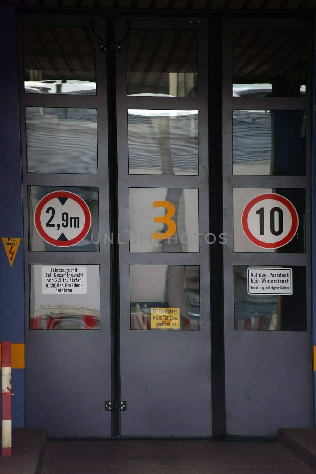 A factory entrance with swingdoors or gates and traffic signs.