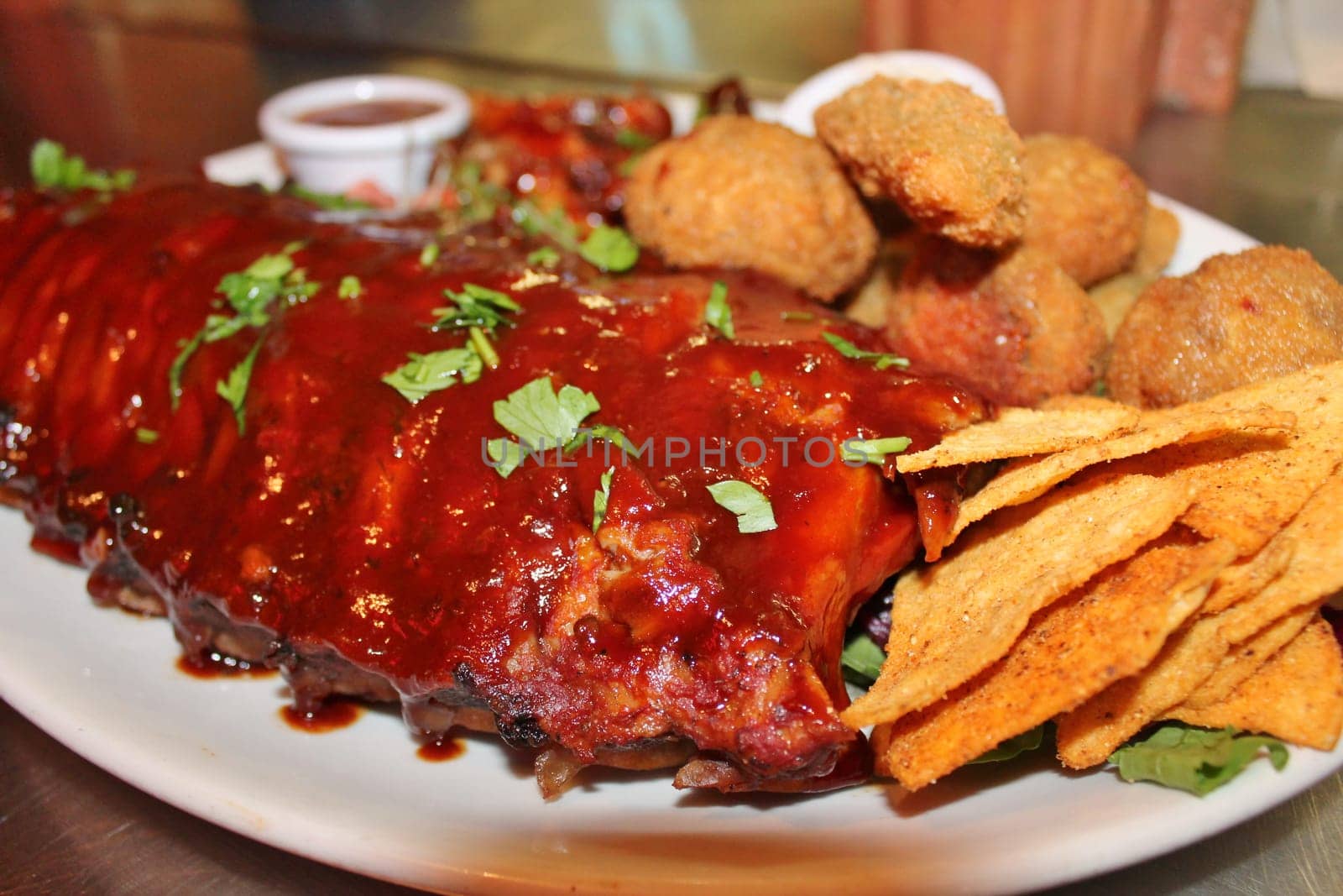 delicious bbq baby-back pork ribs with smokey bbq sauce platter of tortilla chips