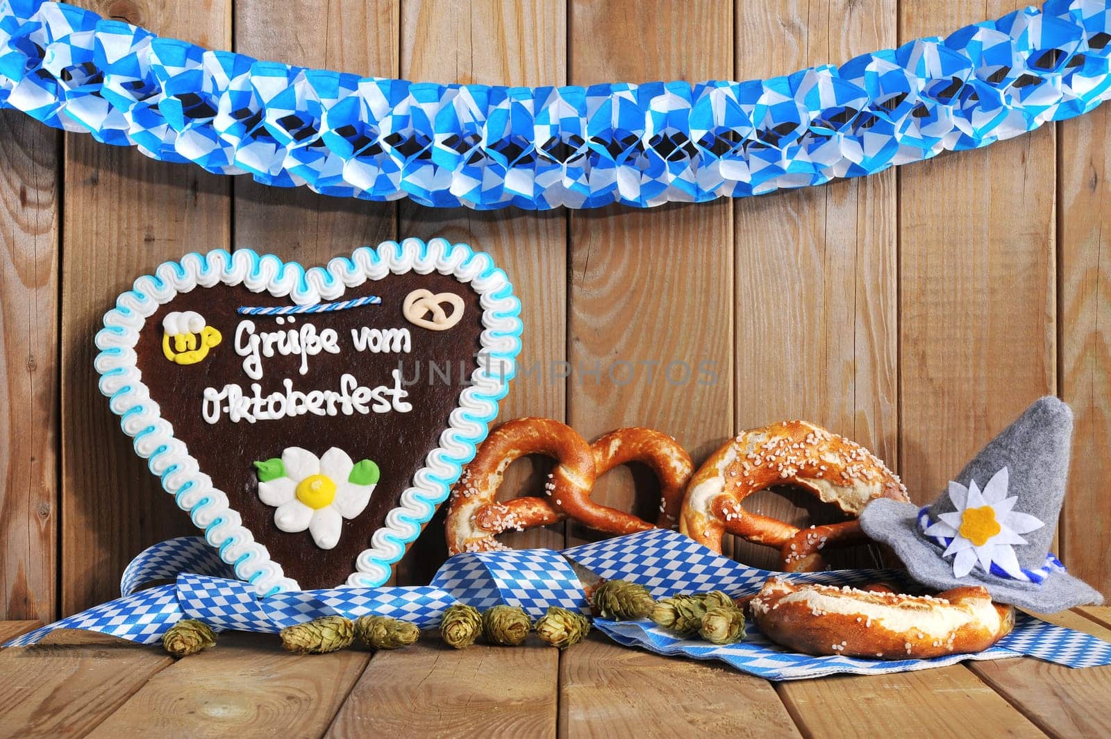 original Bavarian gingerbread heart with Oktoberfest hat and lye brezen in front of old wooden boards