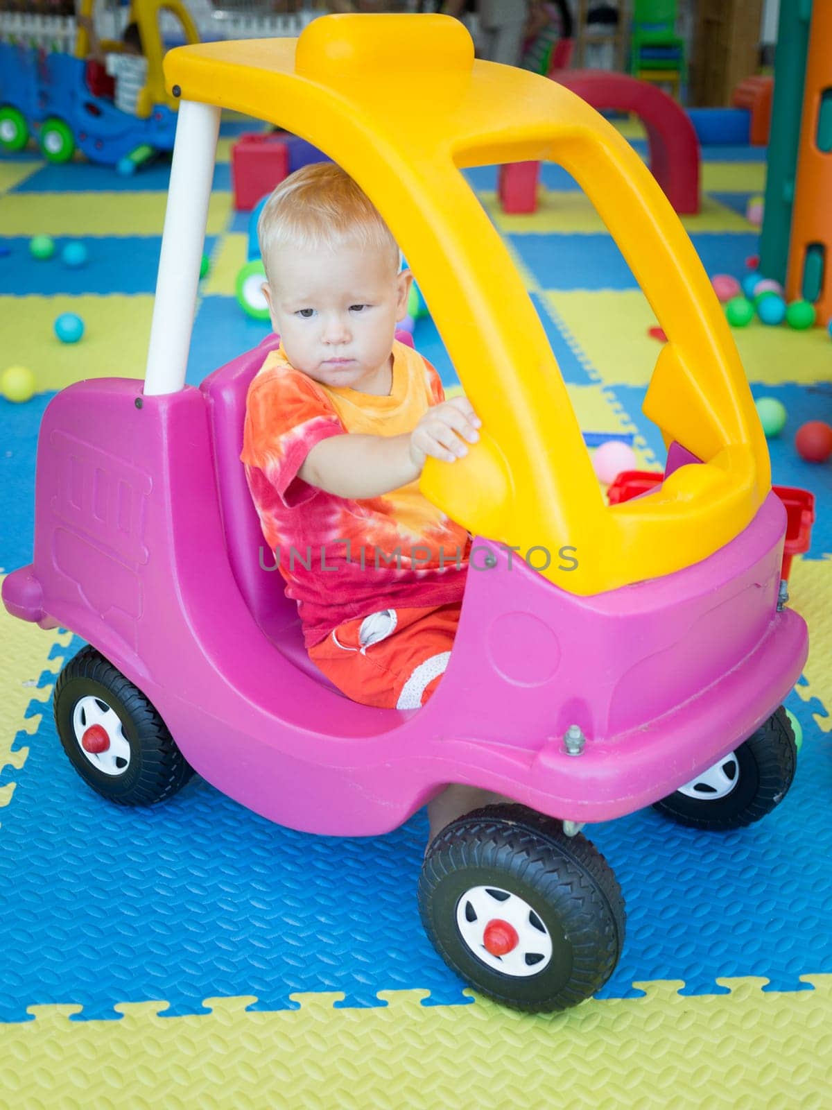 Cute kid boy playing with car