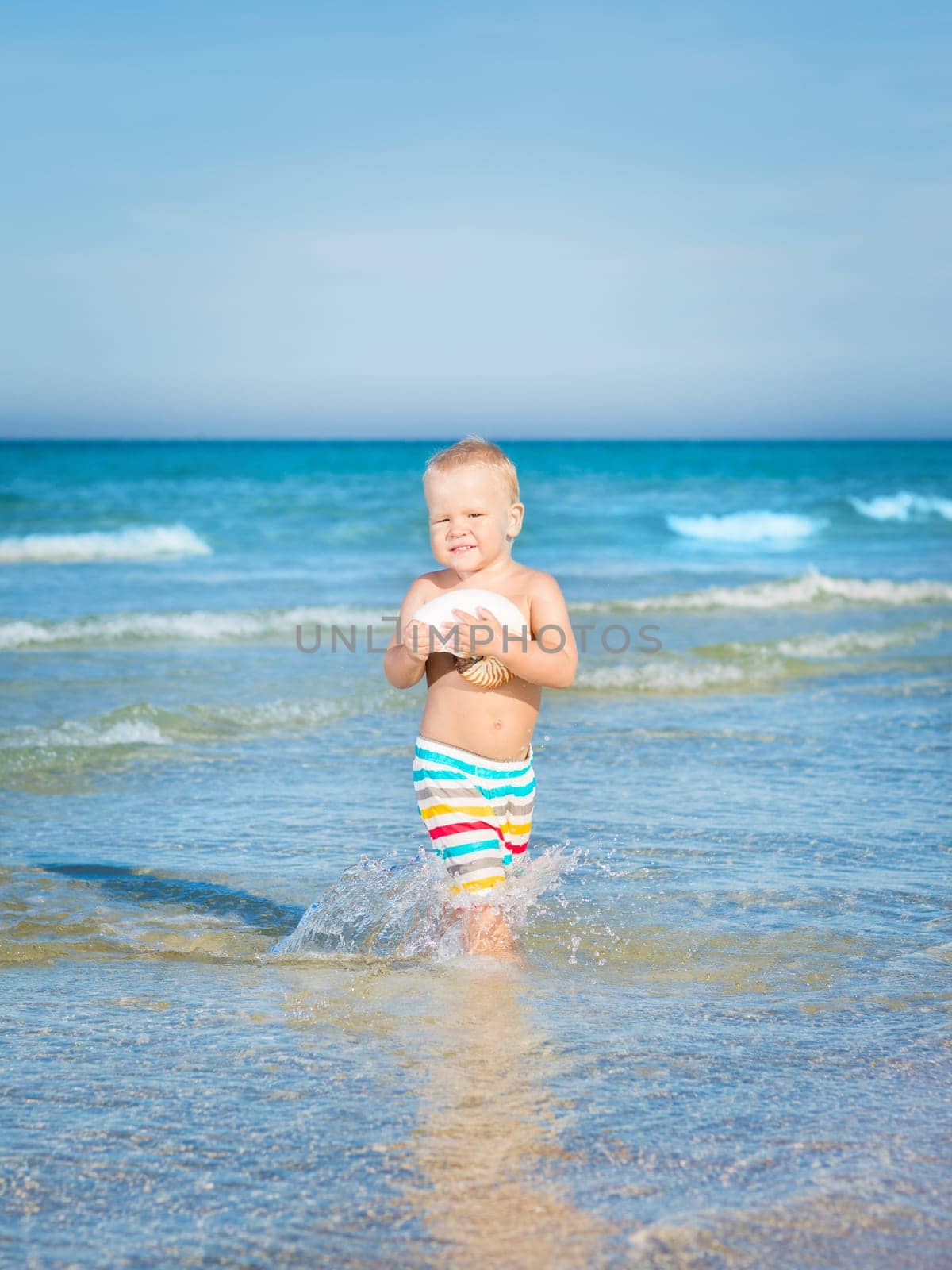 Cute baby plays in a sea
