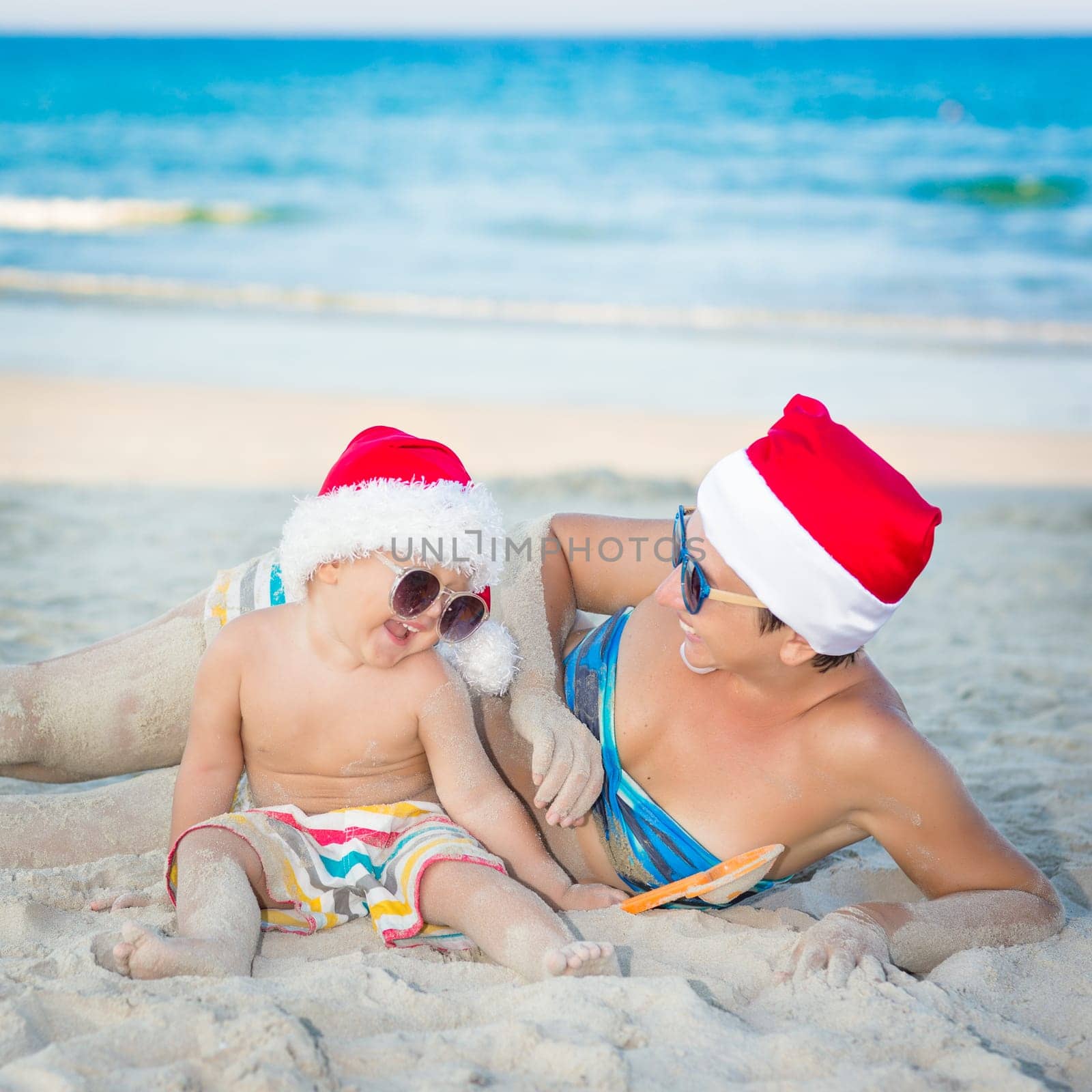 Baby and mother on the beach. Christmas concept