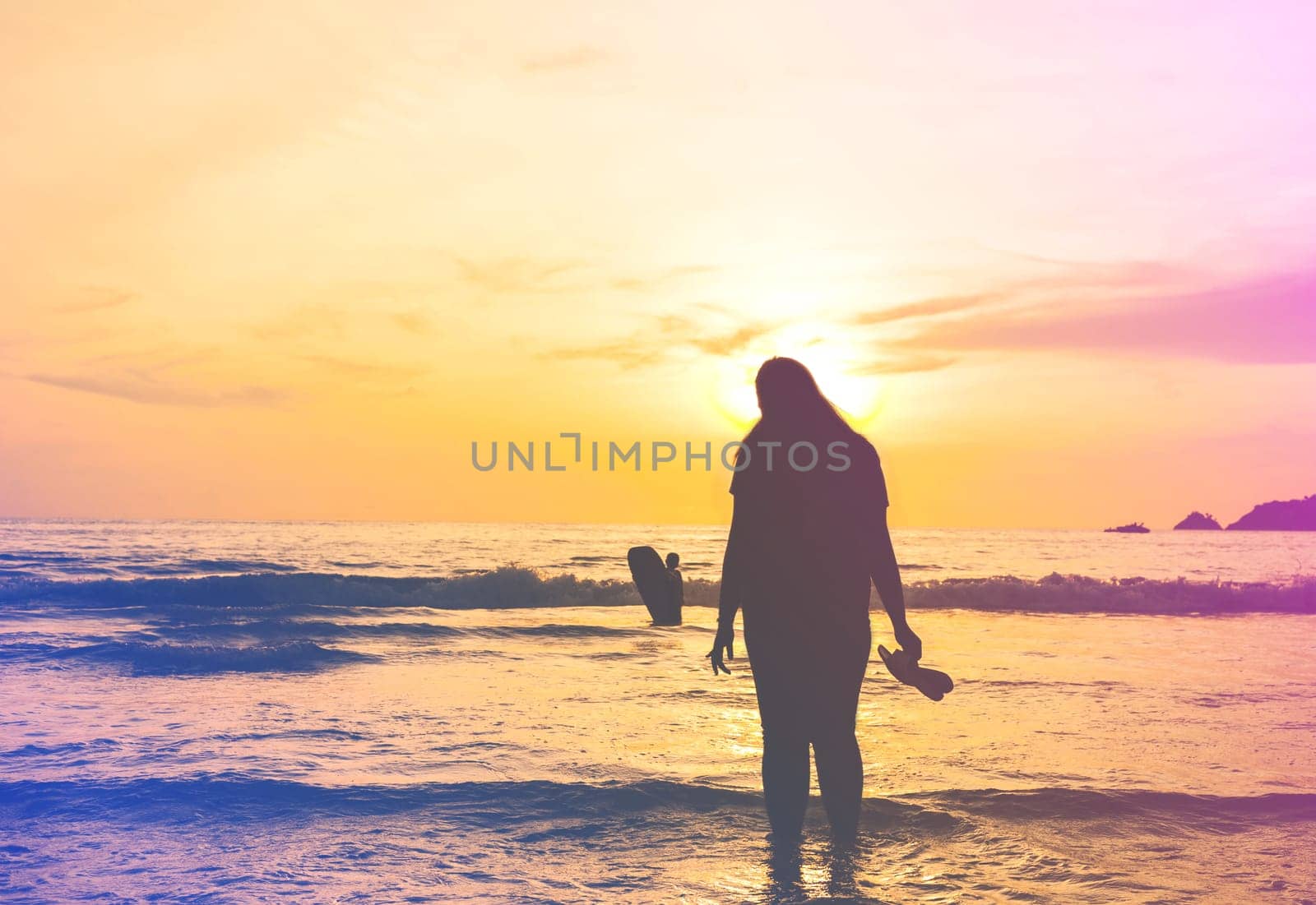 Silhouette vintage women in the sea with color of the sunset, Pathong beach, Phuket Thailand