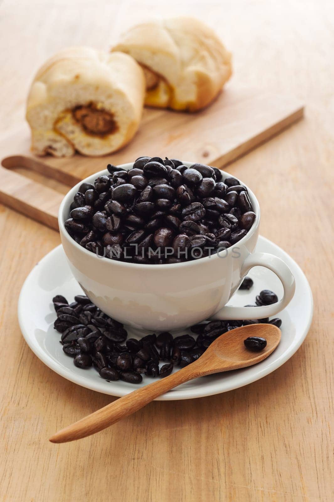 Fresh black coffee in a white cup of coffee with bread cut on wooden background