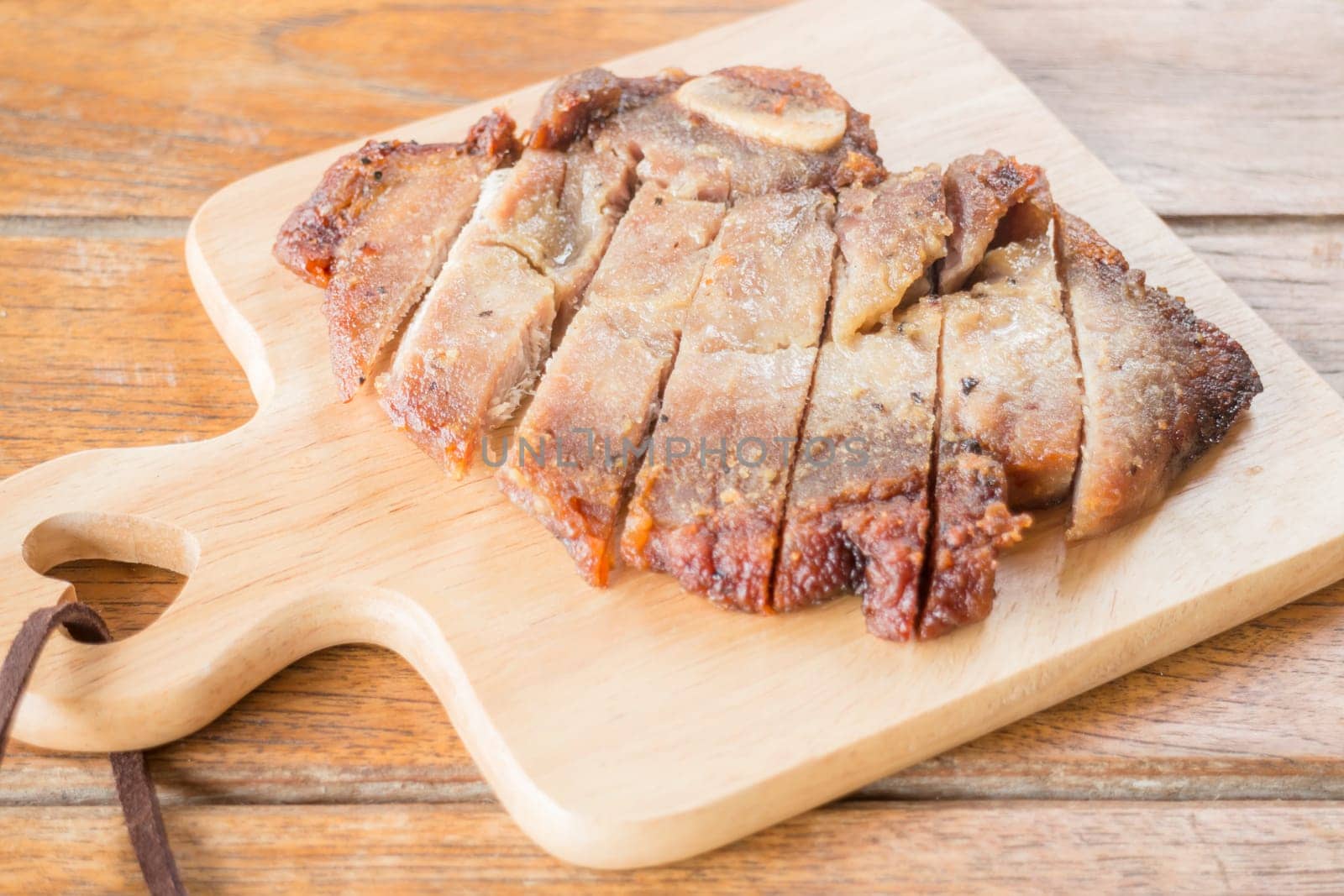 Pork steak on wooden plate, stock photo