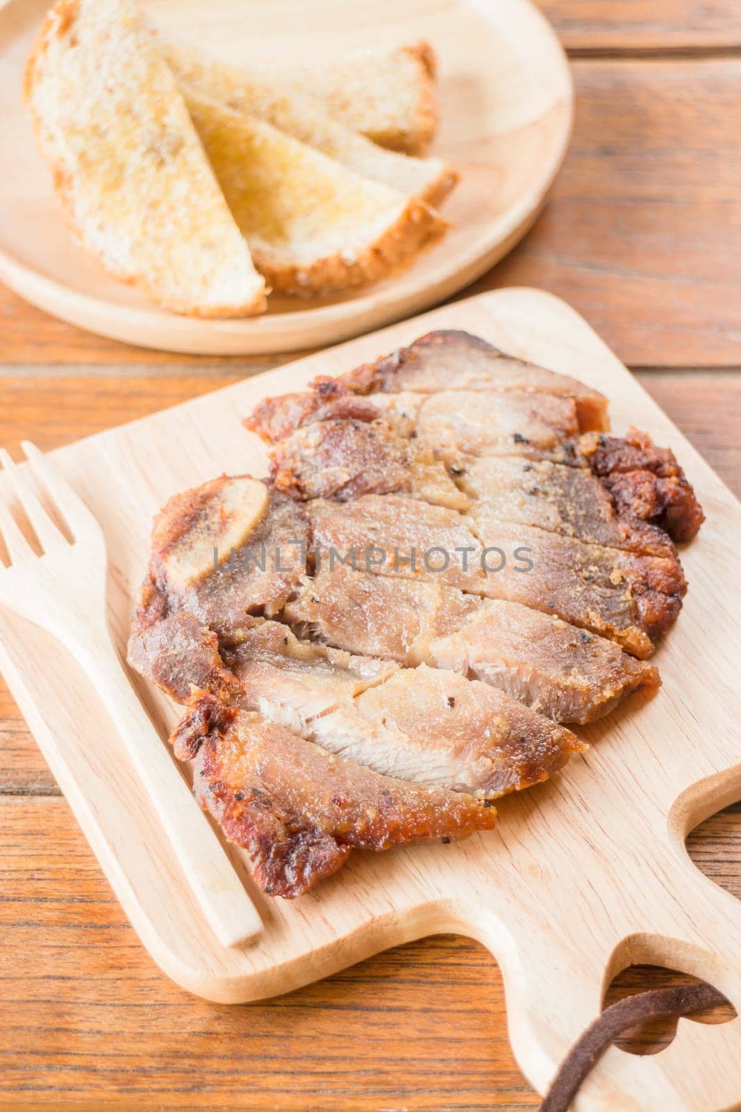 Pork steak on wooden plate, stock photo