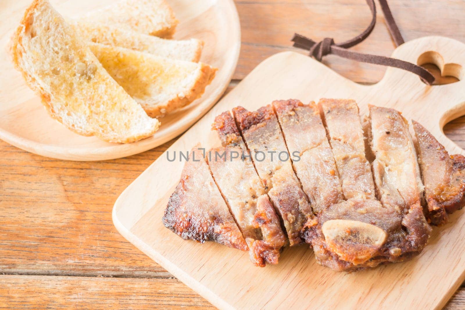 Pork steak on wooden plate, stock photo