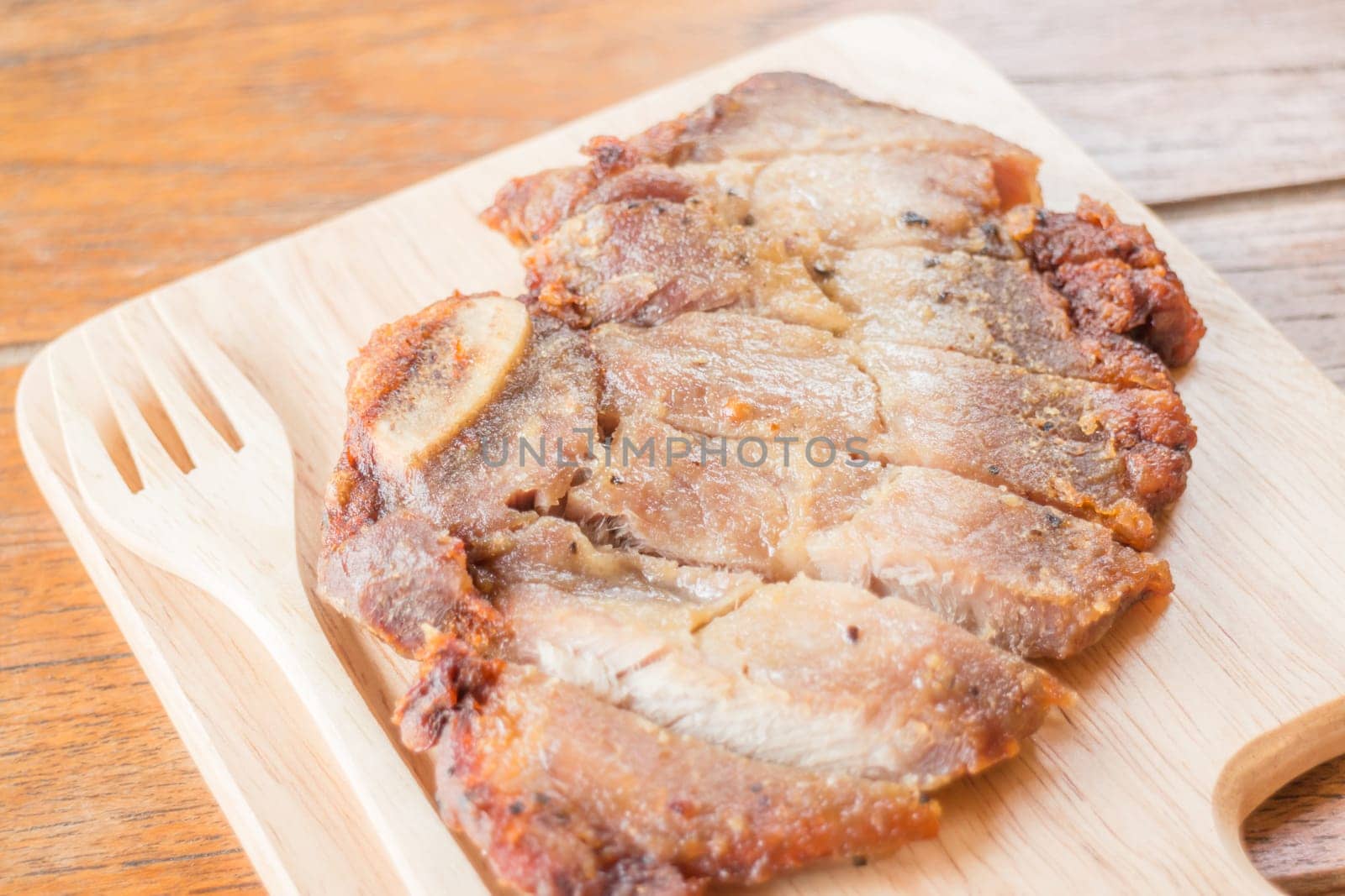 Pork steak on wooden plate, stock photo
