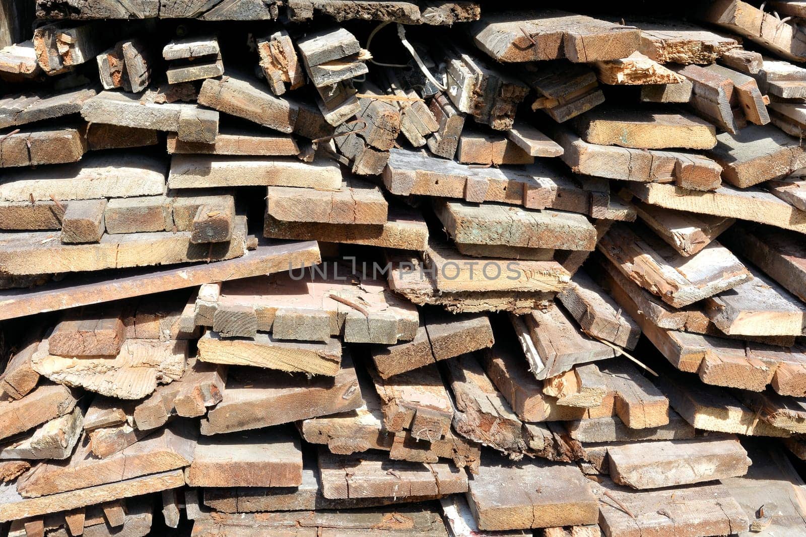 Stack of firewood from a demolition house in front of a house