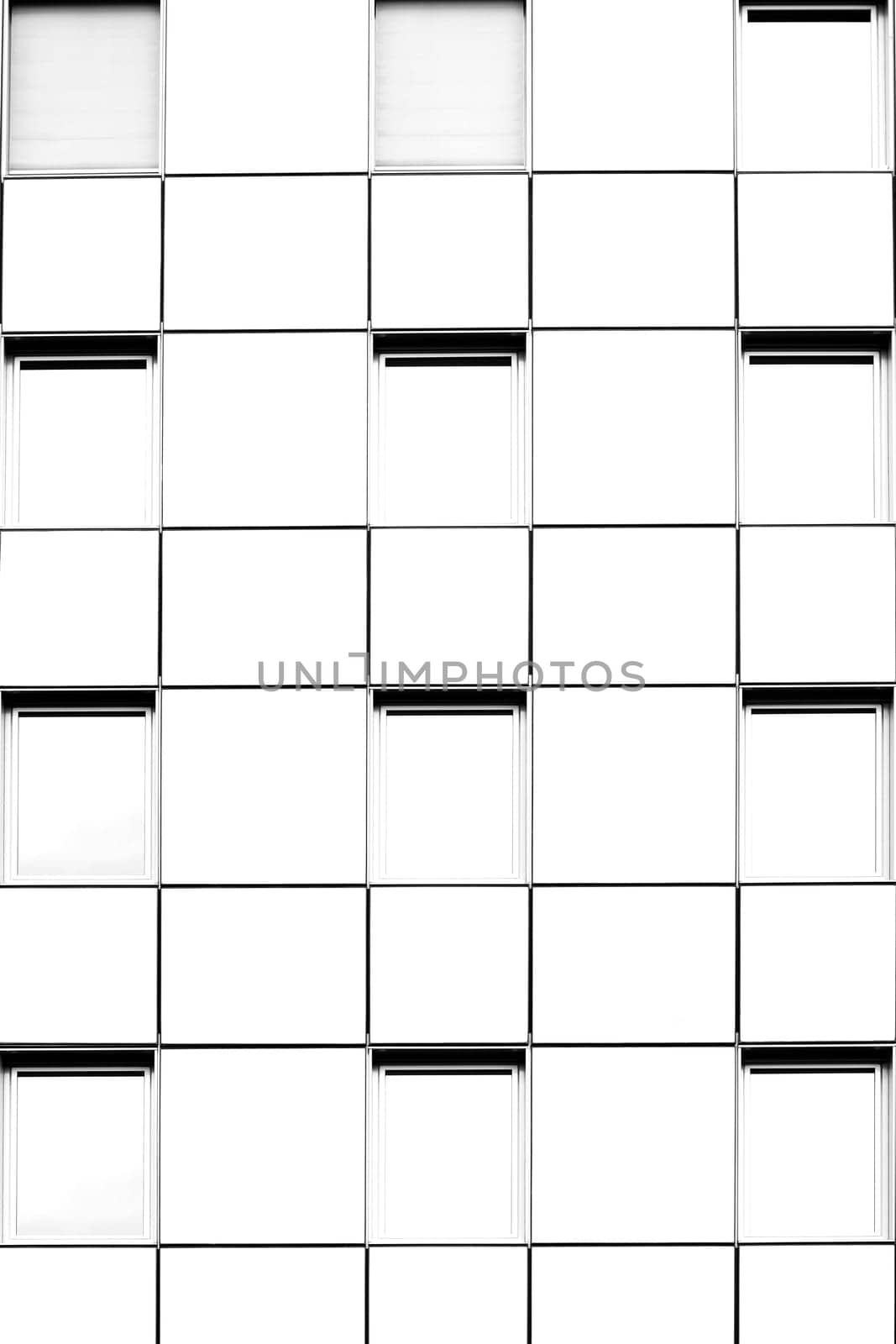 The bright white facade of a multi-storey house with symmetrically arranged windows.