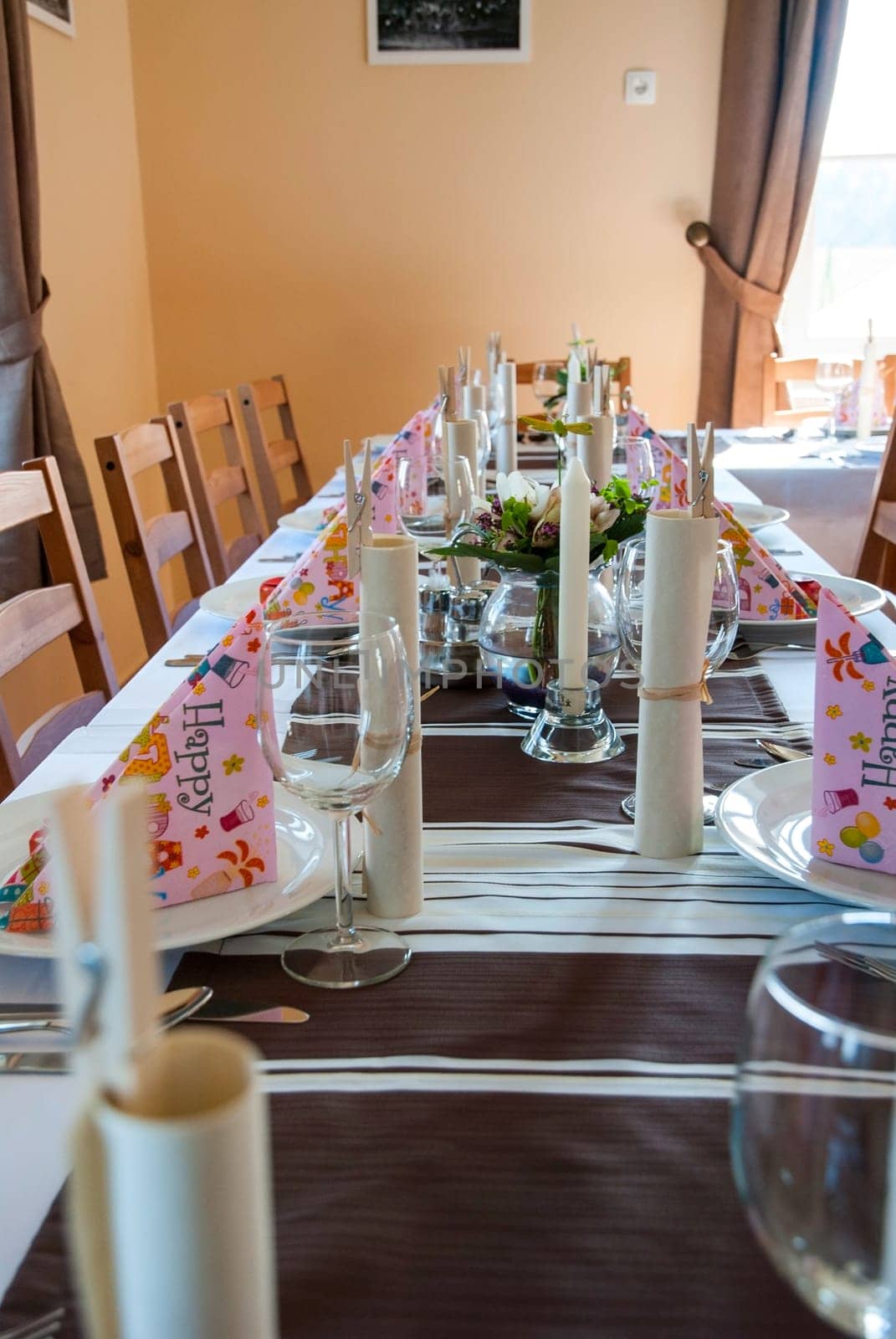 Birthday table decoration with plates, glasses, napkins and flowers