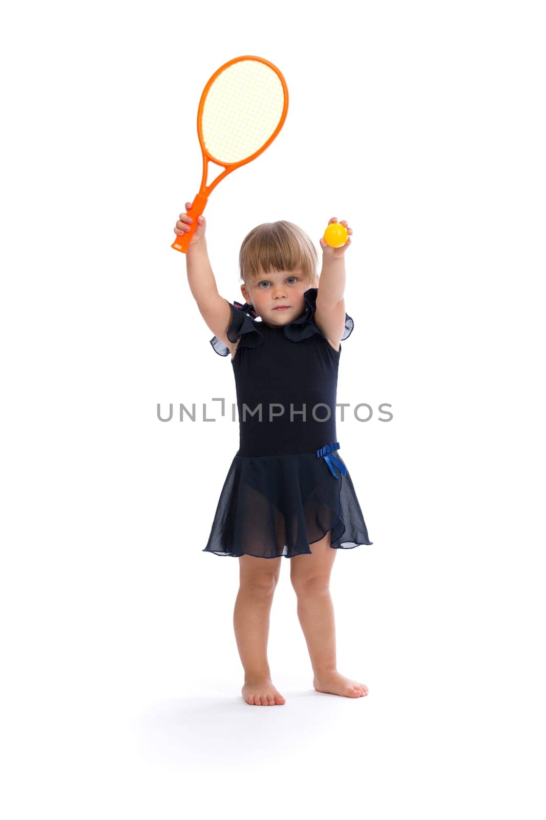 Little girl playing tennis in the studio. Isolate on white.