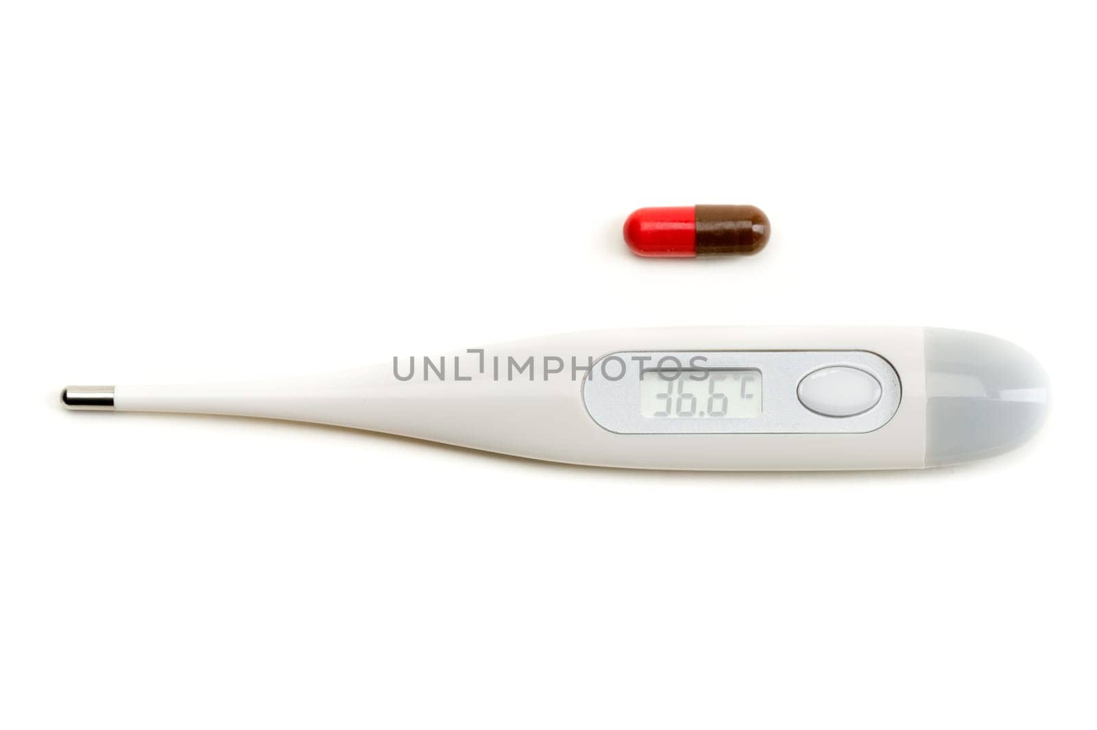 Electronic thermometer and pill on white isolate.