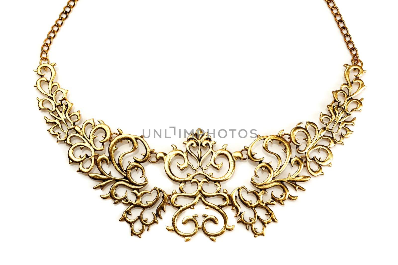 Golden necklace in the shape of tree branches on a white background mirror. Isolate.