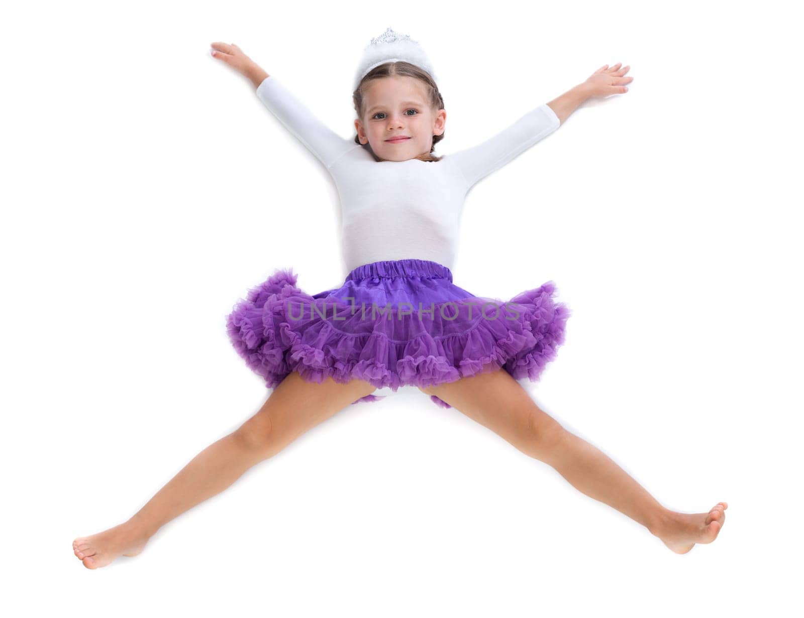 Little girl dancer lying on the floor in the shape of a star. Isolate on white.