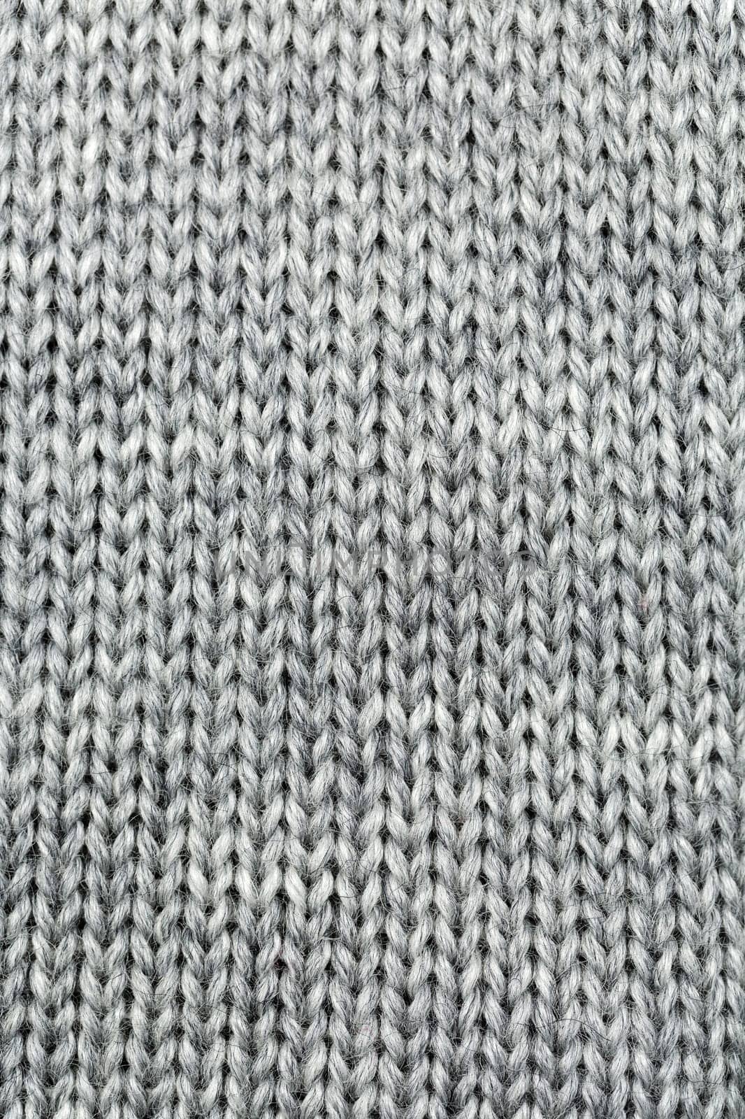 Grey knitted background of natural wool closeup.