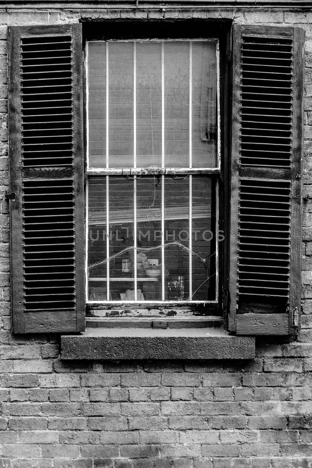 Open window shutters on an old, crumbling building.