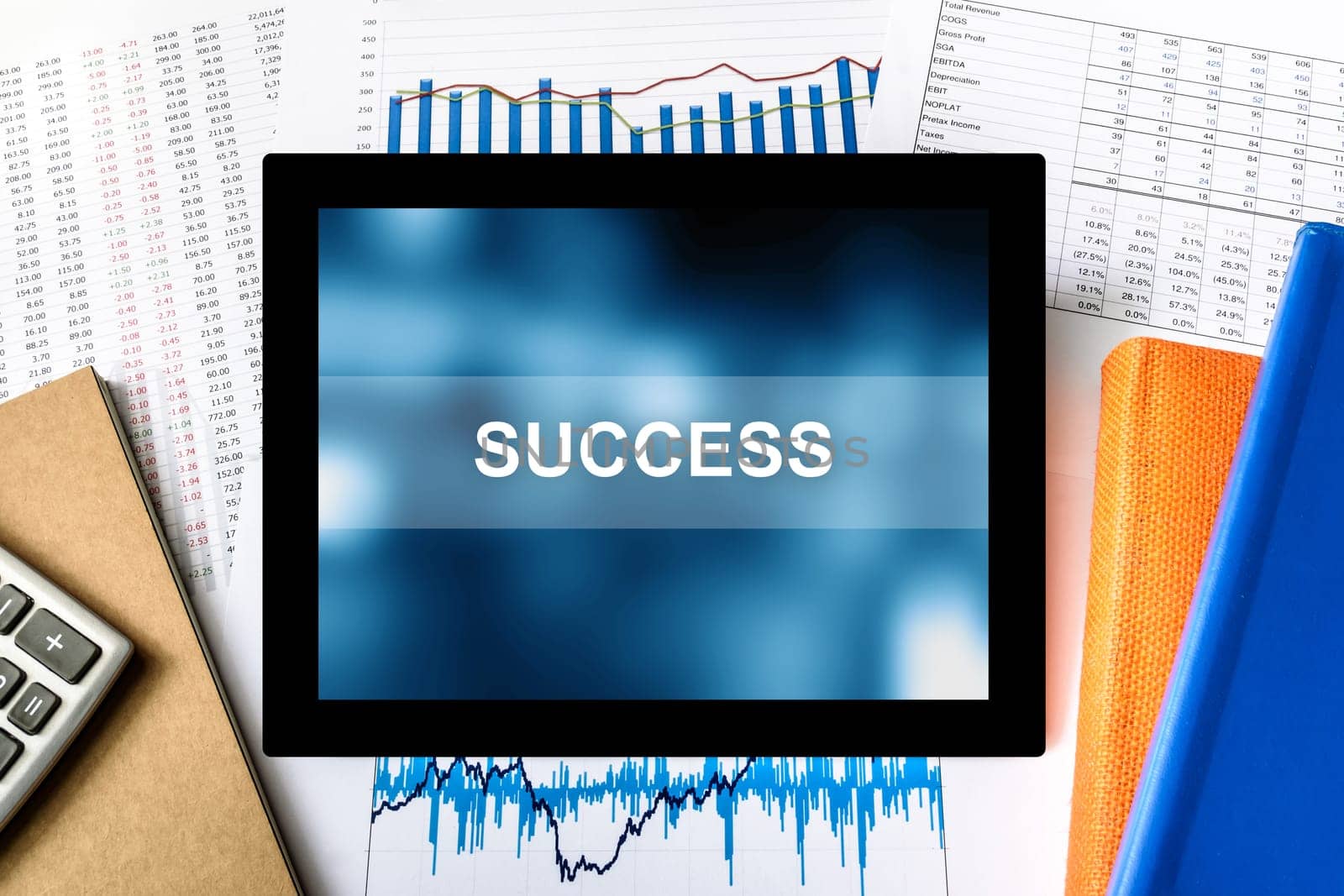 success word on tablet with financial graph background