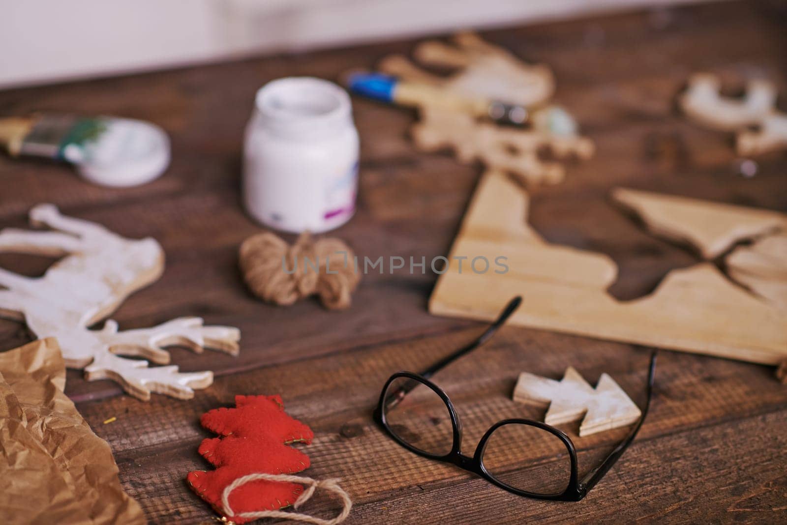 Eyeglasses and various craft objects on wooden table