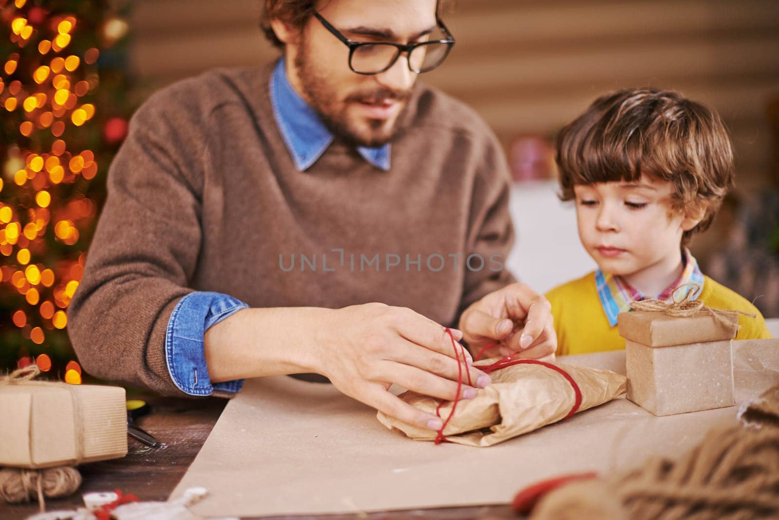 Young man and his son packing xmas gifts