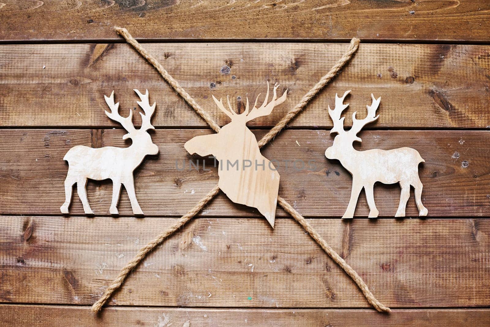 Three reindeers and two ropes on wooden background