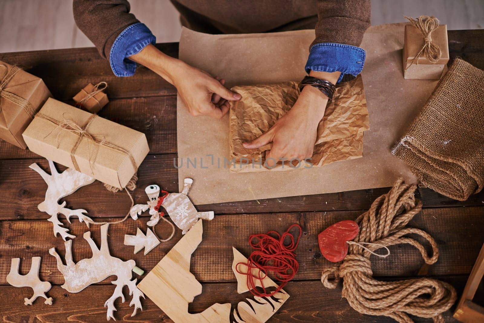 Hands of young man wrapping xmas gift into paper
